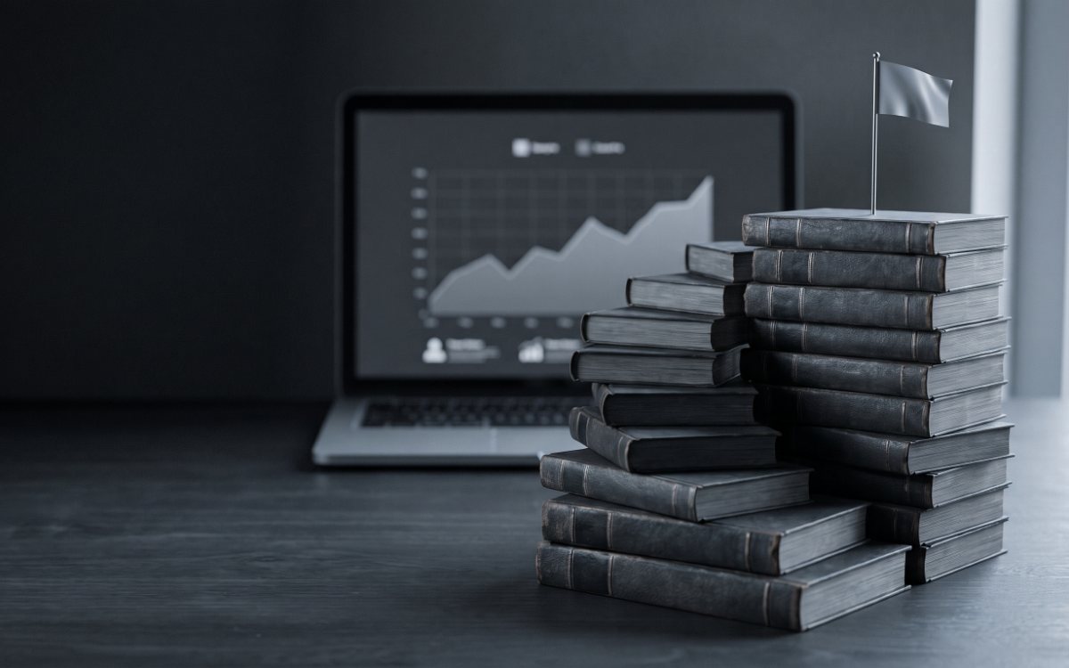 Лестница из тёмных книг с серебряным флажком наверху и ноутбук с растущим графиком