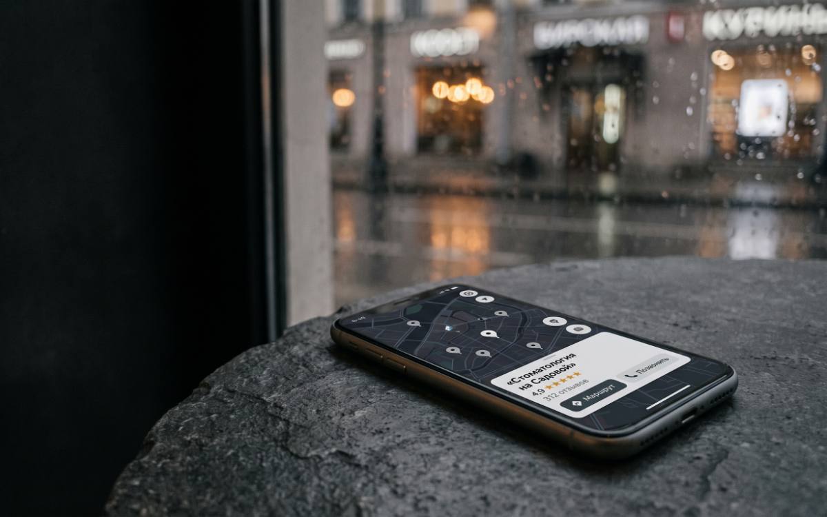 Смартфон с картой города и карточкой клиники с рейтингом 4,9